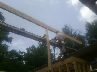 Carpenter setting a ridge beam over a new addition frame — Ice Dam Removal by Roofing Brothers in Sweet Home
