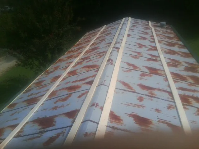 Rusted metal roof panels with new wood purlins before replacement — Storm Damage Roof Repair in Sweet Home by Roofing Brothers