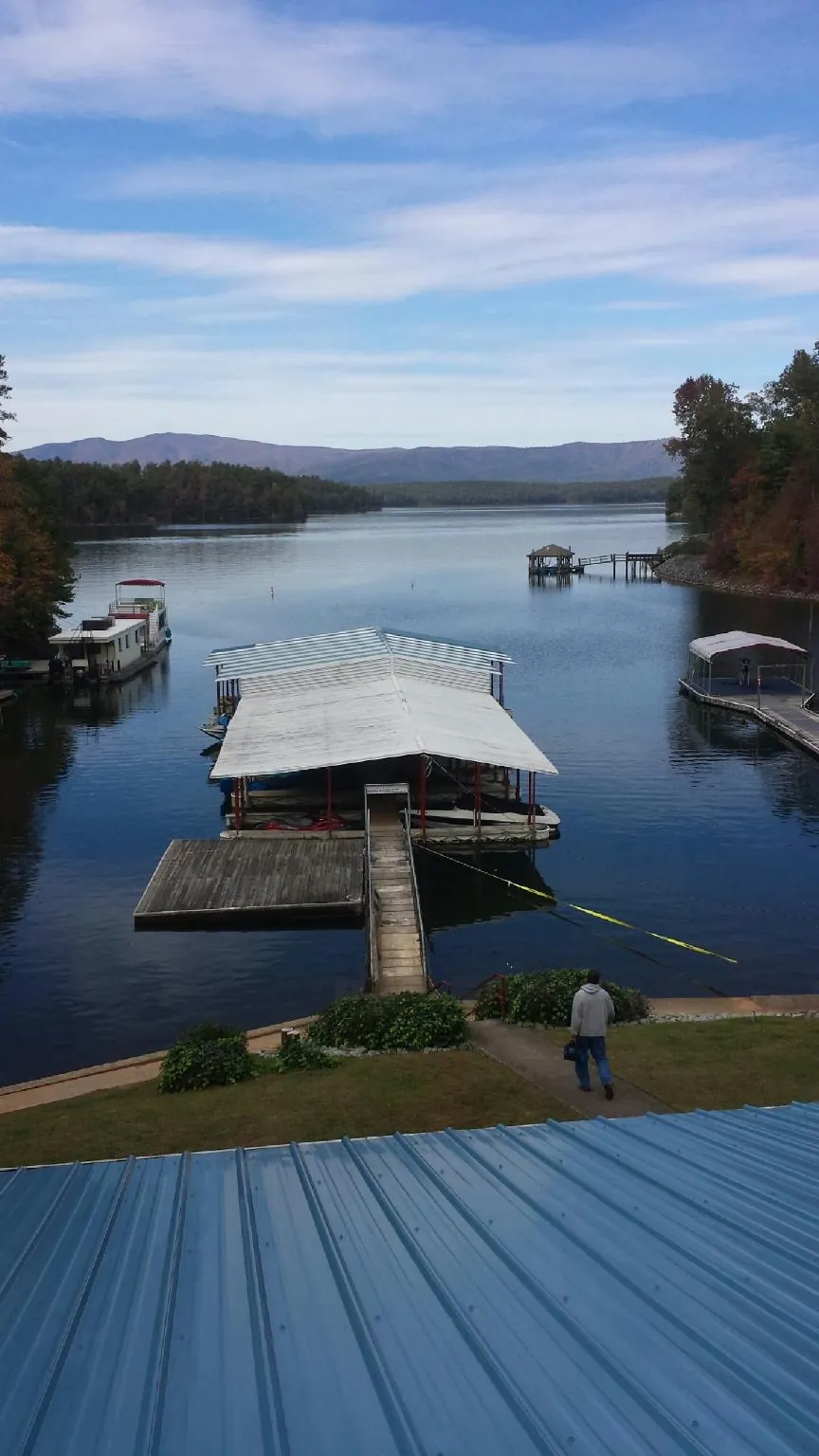 View across a lake from a newly installed blue metal roof in Sweet Home