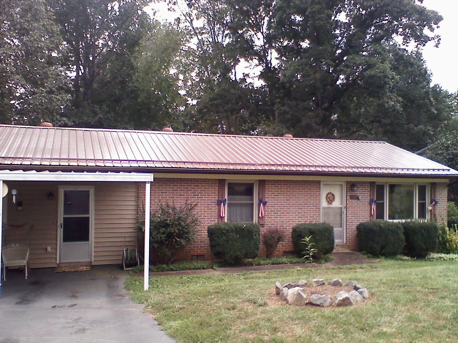 Bronze metal roof and carport on a brick ranch home — Roof Repair work by our crew in Sweet Home